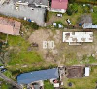 1786 m2 - základová doska - stavebné povolenie + projekt - Mojmírovce - Letecký pohľad na pozemok, s budovou a parkovacími miestami, ideálny pre bývanie.