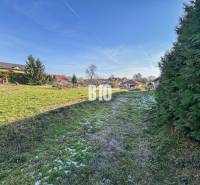 1786 m2 - základová doska - stavebné povolenie + projekt - Mojmírovce - Na obrázku vidieť zelený pozemok s domami, vhodný pre bývanie.