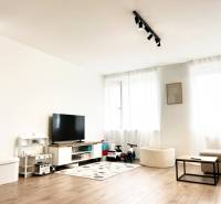 PRENÁJOM exkluzívny 2 izb byt POPRAD s loggiou 53,9 + 8,34 m2 - Obývacia izba v 2-izbovom byte s TV, hračkami a podlahou s dreveným dekorom.