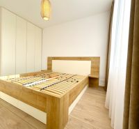 PRENAJATÝ PRENÁJOM nadštandardný 2 izb byt Poprad Karpatská - Spálňa s posteľovým rámom a podlahou s dreveným dekorom v 2-izbovom byte.