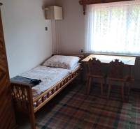CHALUPA v rekreačnej oblasti TERCHOVÁ - ZÁZRIVÁ  - Izba v rodinnom dome s posteľou, oknom, stolom a stoličkami.