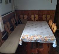 CHALUPA v rekreačnej oblasti TERCHOVÁ - ZÁZRIVÁ  - Jedáleň v rodinnom dome s drevenými stoličkami a stolom, stenu zdobia obrazy a kríž.