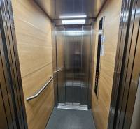 Kompletne zrekonštruovaná garsónka - BA Nové mesto - Vnútro výťahu s panelmi s dreveným dekorom a nerezovými prvkami.