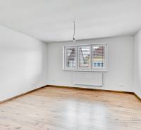 3-izbový moderne zrekonštruovaný rodinný dom v obci Jaslovské Bohunice - Prázdna izba v rodinnom dome s podlahou s dreveným dekorom a bielymi stenami.