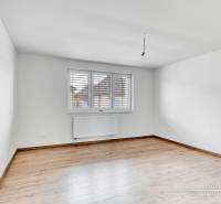 3-izbový moderne zrekonštruovaný rodinný dom v obci Jaslovské Bohunice - Izba s bielymi stenami a podlahou s dreveným dekorom v rodinnom dome.