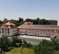 NOVÝ 2 - IZB. BYT (63m2), SENICA - SADOVÁ - Budova na Sadovej ulici v Senici s červenou strechou a solárnymi panelmi.