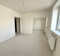 NOVÝ 2 - IZB. BYT (63m2), SENICA - SADOVÁ - Svetlá miestnosť, priestranné okno, biele steny a radiátor v 2-izbovom byte.