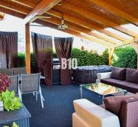 Rodinný dom Čierne pri Čadci + pozri video - Terasa rodinného domu so sedením a grilom, čiastočne krytá s drevenou strechou.