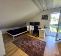 Rodinný dom Čierne pri Čadci + pozri video - Podkrovná izba s pracovným stolom, posteľou a balkónovými dverami v Rodinnom dome.