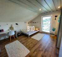 Rodinný dom Čierne pri Čadci + pozri video - Detská izba v podkroví rodinného domu s posteľou, stolom a dekoráciami.