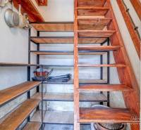 REZERVOVANÉ Starší 2-izbový rodinný dom v obci Dobrá Voda - Úložný priestor pod schodmi s regálmi a kuchynským vybavením v rodinnom dome.