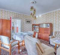 REZERVOVANÉ Starší 2-izbový rodinný dom v obci Dobrá Voda - Obývacia izba v rodinnom dome s retro nábytkom a podlahou s dreveným dekorom.