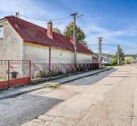 REZERVOVANÉ Starší 2-izbový rodinný dom v obci Dobrá Voda - Rodinný dom na ulici Dobrá Voda v Dobrej Vode, obklopený zeleňou a modrou oblohou.