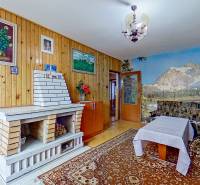 Rodinný dom, Kamienka, okr. Stará Ľubovňa - Obývacia izba v rodinnom dome s krbom, drevenými obkladmi a horskou tapetou.