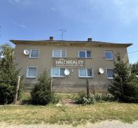 REZERVOVANÉ - Predaj, trojizbový byt Bošany - EXKLUZ... - Bytový dom obklopený zeleňou v Bošanoch s viacerými satelitnými anténami na fasáde.