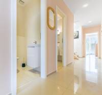Moderný rodinný dom s bazénom v Trnave!!! - Chodba v Rodinnom dome so svetlými dlaždicami, otvorené dvere do kúpeľne, zrkadlo na stene.