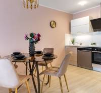 Moderný rodinný dom s bazénom v Trnave!!! - Jedáleň s okrúhlym stolom a kuchynskou linkou v rodinnom dome, podlaha s dreveným dekorom.