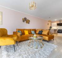 Moderný rodinný dom s bazénom v Trnave!!! - Obývacia izba v 4-izbovom byte s pohodlnou sedačkou a podlahou s dreveným dekorom.