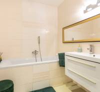 Moderný rodinný dom s bazénom v Trnave!!! - Kúpeľňa so zrkadlom, vaňou a umývadlom v rodinnom dome, svetlé dlaždice.