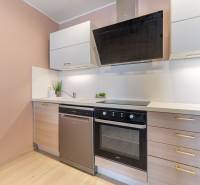 Moderný rodinný dom s bazénom v Trnave!!! - Kuchyňa v 4-izbovom byte s podlahou s dreveným dekorom a modernými spotrebičmi.