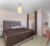 Moderný rodinný dom s bazénom v Trnave!!! - Spálňa v rodinnom dome s veľkou posteľou, šatníkom a podlahou s dreveným dekorom.