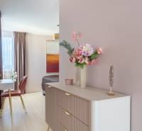 Moderný rodinný dom s bazénom v Trnave!!! - Kvetinová dekorácia na komode, zrkadlo, stolička a podlaha s dreveným dekorom v rodinnom dome.