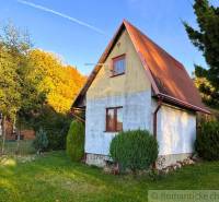 Záhrada s chatkou pod Malými Karpatami, Sološnica - Chata v Sološnici obklopená zeleňou, so sedlovou strechou a udržiavaným trávnikom.