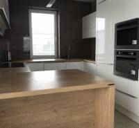 3 izbový byt, 50 m2 terasa, 2PS, Gajarská ulica, Záhorská Bystrica - Kuchyňa v 3-izbovom byte s drezom, rúrou a podlahou s dreveným dekorom.