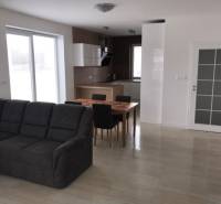 3 izbový byt, 50 m2 terasa, 2PS, Gajarská ulica, Záhorská Bystrica - Obývacia izba s pohovkou a kuchynským stolom v 3-izbovom byte.