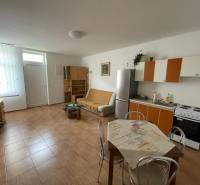 Predaj budovy v centre mesta - Interiér rodinného domu s kuchynským kútom a podlahou s dreveným dekorom.