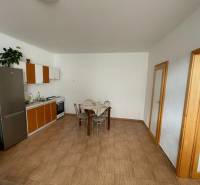 Predaj budovy v centre mesta - Kuchyňa v rodinnom dome s dlažbou a jedálenským stolom.