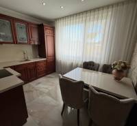 PREDAJ : ŠTÝLOVÝ RODINNÝ DOM S BAZÉNOM, KOMÁRNO - Kuchyňa s tmavými skrinkami, bielymi závesmi a kvetinovou dekoráciou v rodinnom dome.