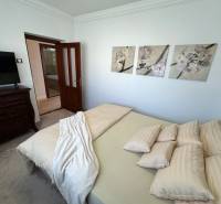 PREDAJ : ŠTÝLOVÝ RODINNÝ DOM S BAZÉNOM, KOMÁRNO - Spálňa rodinného domu s dekoračnými obrazmi na stene, čalúneným nábytkom a dverami.