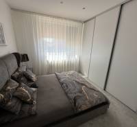 PREDAJ : ŠTÝLOVÝ RODINNÝ DOM S BAZÉNOM, KOMÁRNO - Spálňa v rodinnom dome s tmavým posteľným prádlom a veľkou skriňou.