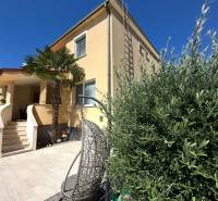 PREDAJ : ŠTÝLOVÝ RODINNÝ DOM S BAZÉNOM, KOMÁRNO - Rodinný dom v Komárne s terasou, záhradným kreslom a palmovým stromom na dvore.