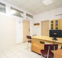 Na predaj ambulancia 101m2, Bratislavská ul. - Žilina - Kancelárie so stolom, stoličkou, počítačom a skriňou na svetlej keramickej podlahe.