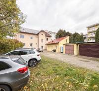 Na predaj ambulancia 101m2, Bratislavská ul. - Žilina - Parkovisko pri kanceláriách na Bratislavskej ulici v Žiline, autá a garáže v pozadí.