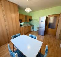 NA PREDAJ 1-IZBOVÝ BYT (37m2), SENICA, HVIEZDOSLAVOVA UL. - Kuchyňa v 1-izbovom byte s podlahou s dreveným dekorom a jedálenským stolom.