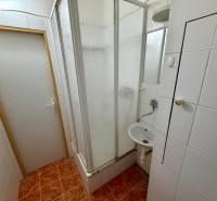 NA PREDAJ 1-IZBOVÝ BYT (37m2), SENICA, HVIEZDOSLAVOVA UL. - Kúpeľňa so sprchovým kútom a bielymi obkladačkami v 1-izbovom byte.