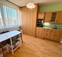 NA PREDAJ 1-IZBOVÝ BYT (37m2), SENICA, HVIEZDOSLAVOVA UL. - Kuchyňa v 1-izbovom byte s podlahou s dreveným dekorom a jedálenským stolom.