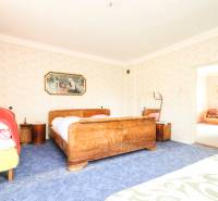 5i RD s garážou, Čierna Lehota, okr. Bánovce n./B. - Spálňa v rodinnom dome s dreveným nábytkom a bohatým vzorovaným kobercom.