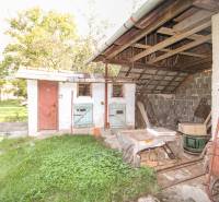 5i RD s garážou, Čierna Lehota, okr. Bánovce n./B. - Dvor rodinného domu v Čiernej Lehote s prístreškom a záhradným vybavením.