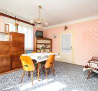 5i RD s garážou, Čierna Lehota, okr. Bánovce n./B. - Interiér rodinného domu s retro nábytkom, kobercom a svetlými stenami s tapetou.