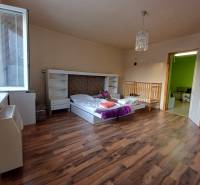 Pekný rodinný dom v obci Dlhá Ves. - Detská izba v rodinnom dome s posteľou, postieľkou a podlahou s dreveným dekorom.