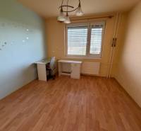 3 izbový byt  balkónom Topoľčany Juh - Izba v 3-izbovom byte s podlahou s dreveným dekorom a pracovným stolom.