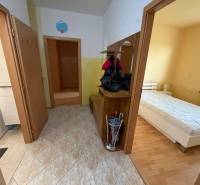 3 izbový byt  balkónom Topoľčany Juh - Chodba v 3-izbovom byte s dlažbou, vstupom do kúpeľne a spálne s dreveným dekorom podlahy.