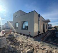 NA PREDAJ 4-IZBOVÝ RODINNÝ DOM (ČASŤ DVOJDOMU), HUBICE - Rodinný dom v Hubiciach vo výstavbe s neúpravou terénu. Jasná obloha a slnečné svetlo.