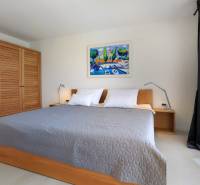 NA PREDAJ moderná vila /251 m²/ v atraktívnej lokalite, ostrov Krk - Spálňa vo Vile s veľkou posteľou, drevenou skriňou a obrazom na stene.