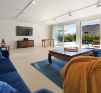 NA PREDAJ moderná vila /251 m²/ v atraktívnej lokalite, ostrov Krk - Obývacia izba vo vile s tmavomodrým nábytkom, TV a veľkými oknami.