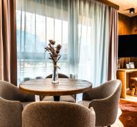 Na predaj krásny apartmám v Štrbe - Jedálenský kút v 2-izbovom byte s podlahou s dreveným dekorom a výhľadom z okna.